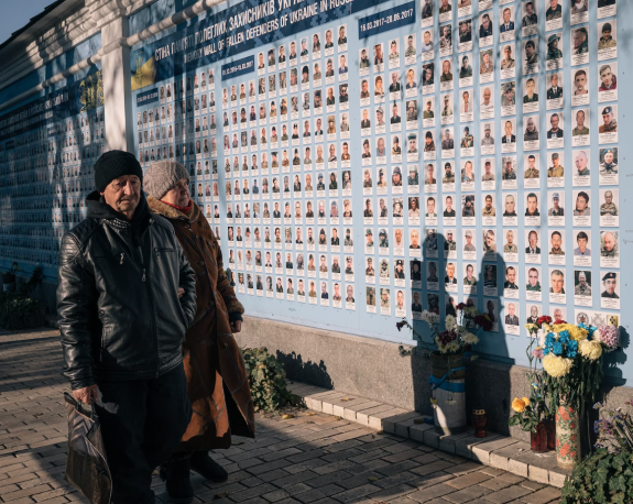 Фотографии убитых украинских и иностранных солдат и волонтеров выставлены на стене возле Михайловского собора в Киеве.