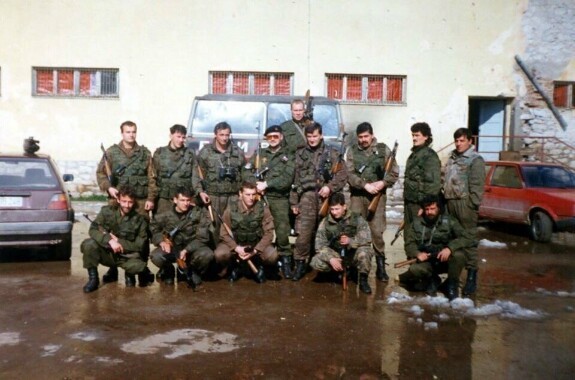 Бойцы отряда «Белые волки», а так же их командир Срджан Кнежевич (четвертый справа стоит) и Светко Гачанин (третий слева стоит) на базе в местной школе города Трново, март 1995 года. На фото присутствуют русские добровольцы Юрий Шарапов из Красноярска (в берете и очках по центру) и Владимир Савин «Боцман» из Мурманска (с снайперской винтовкой на плече за Кнежевичем и Шараповым). Также на фото румынский доброволец и бывший офицер Секурита́те Адриан Дима (стоит крайний слева).