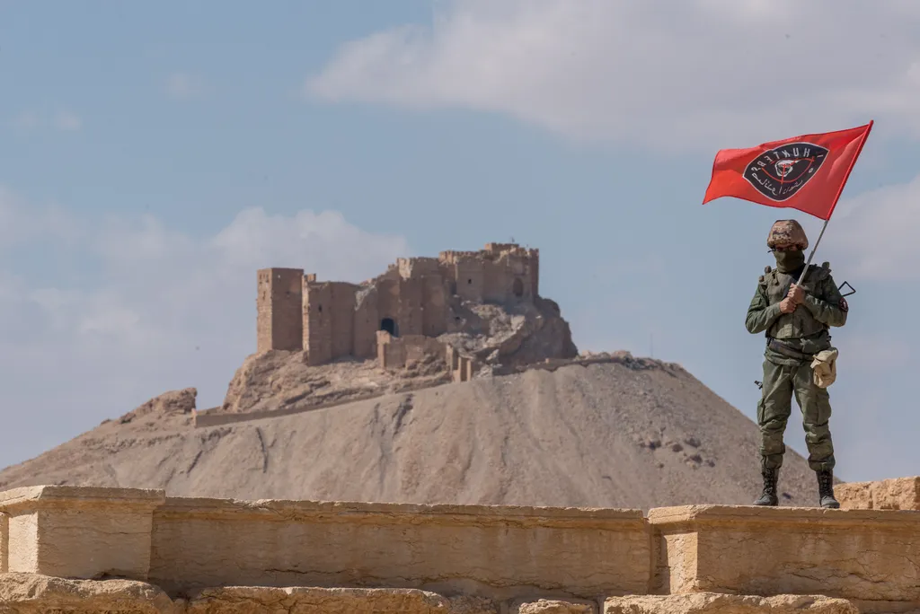 An ISIS Hunters fighter on the roof of the amphitheater, with the Palmyra Citadel in the background. PHOTO: Stepan Yatsko