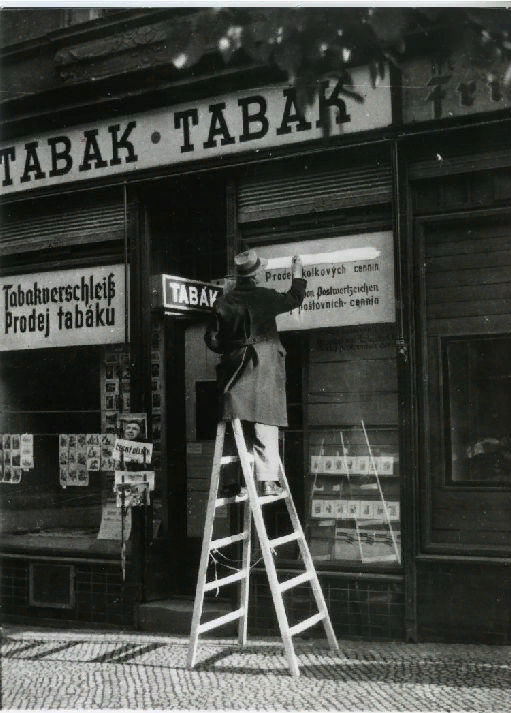 Владелец магазина в Праге замазывает надпись на немецком языке 5 мая 1945 года.