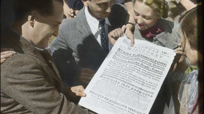 Жители Варшавы ликуют, читая газету, которая уверяет их, что США не остались нейтральными, сентябрь 1939 года.