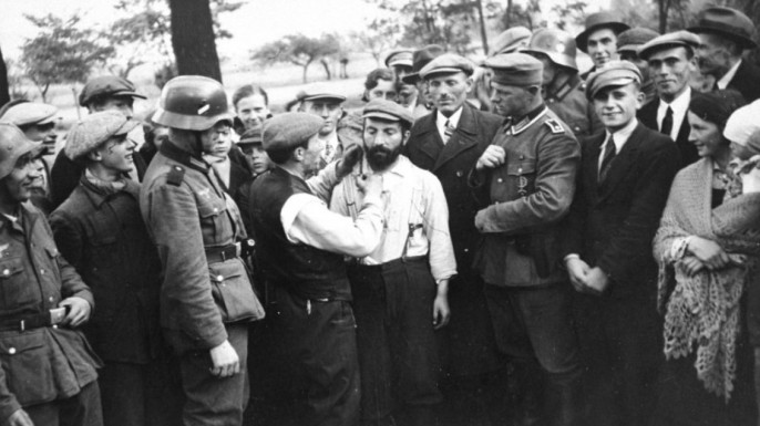 Немецкие солдаты и жители города Томашов-Мазовецкий смотрят как еврею отстригают пейсы.