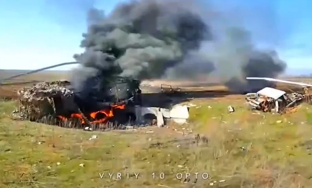 Справа обломки легковушки, слева горит нечто колесное. Под ним нечто вроде мостика — возможно он поможет впоследствии определить точное место.