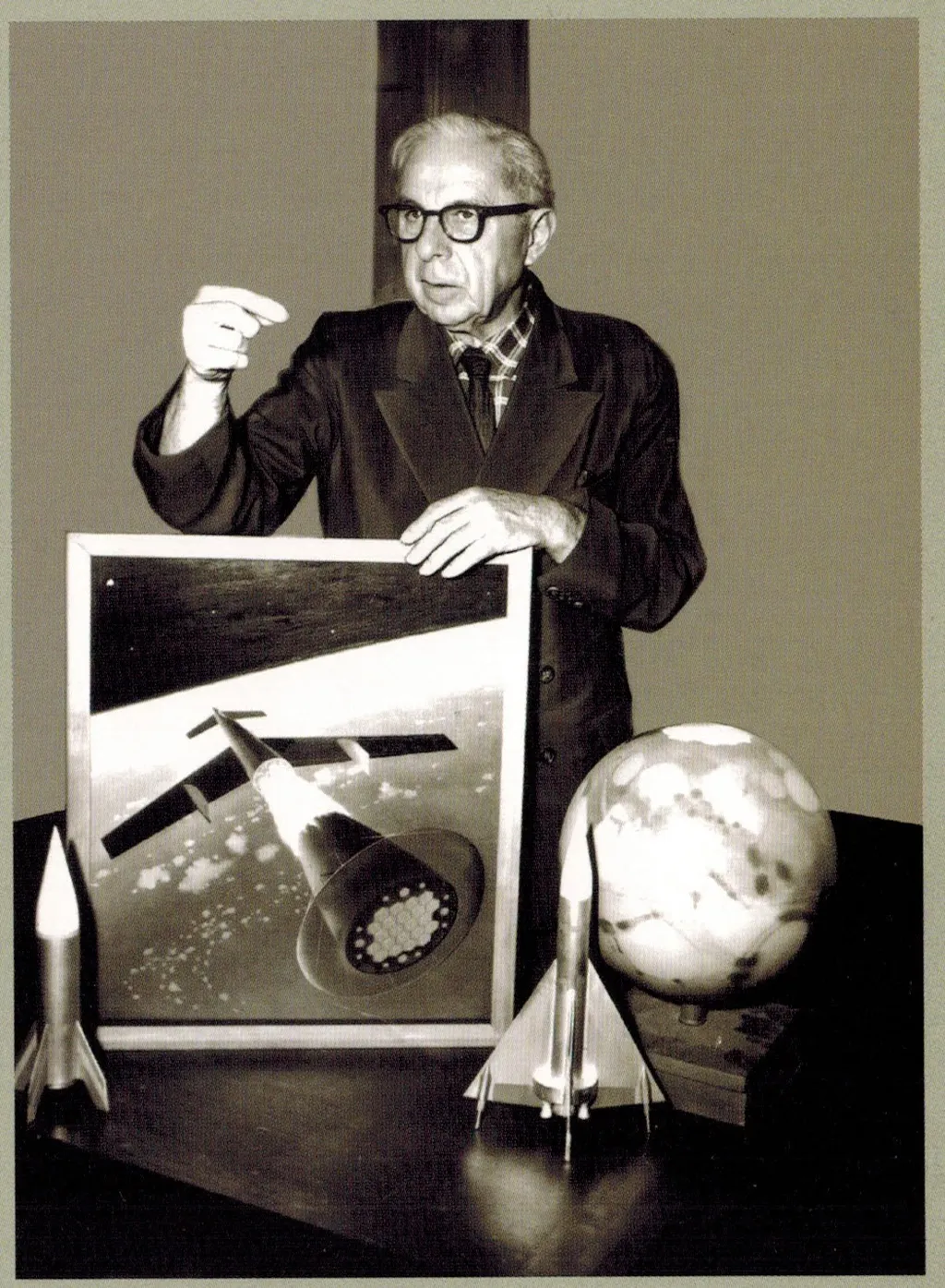 Легендарный художник Чесли Бонстелл рассказывает, как он всё это рисовал. На картине - третья ступень парома отбрасывает вторую. На столе - лунник и марсианский космоплан от всё того же визионера. Ну и винтажный глобус Марса, разумеется.